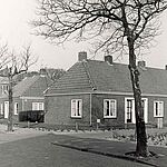 Gezicht op de bejaardenwoningen aan de Kerklaan en het Sint Agnesplantsoen. Op de achtergrond de H. Laurentiuskerk met daarvoor (noodlokaal) de Gemeentelijke Sociale Dienst. Situatie 1968.